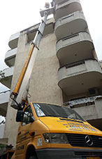 Εξωτερική επισκευή μπαλκονιών πολυκατοικίας χωρίς σκαλωσιά, με χρήση του καλαθοφόρου οχήματος μας.